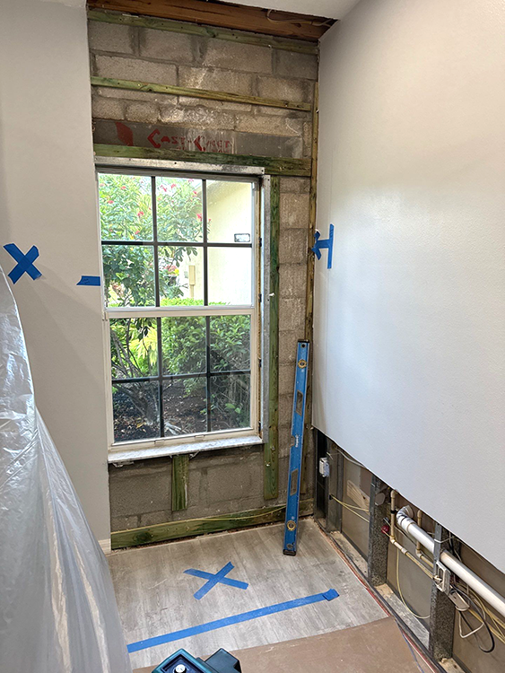 Technician extracting water from a flooded living room during emergency restoration