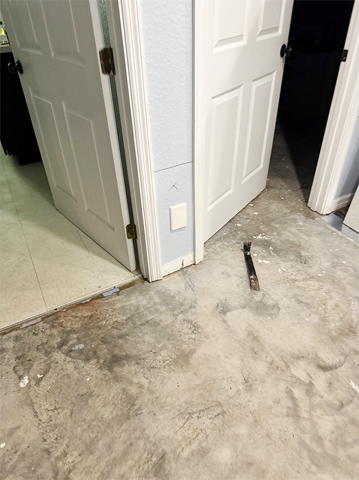 Technician extracting water from a flooded living room during emergency restoration